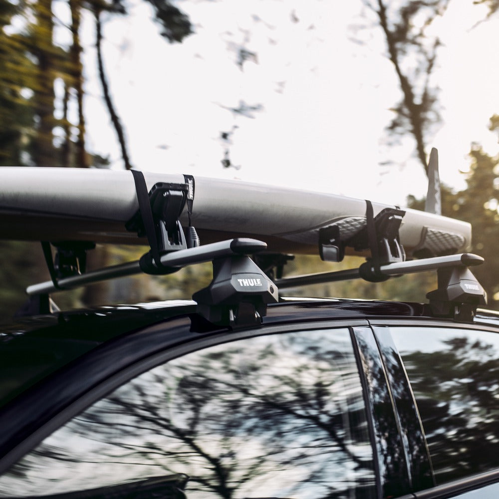 Thule WingBar Evo roof rack carrying a paddleboard on a bare roof